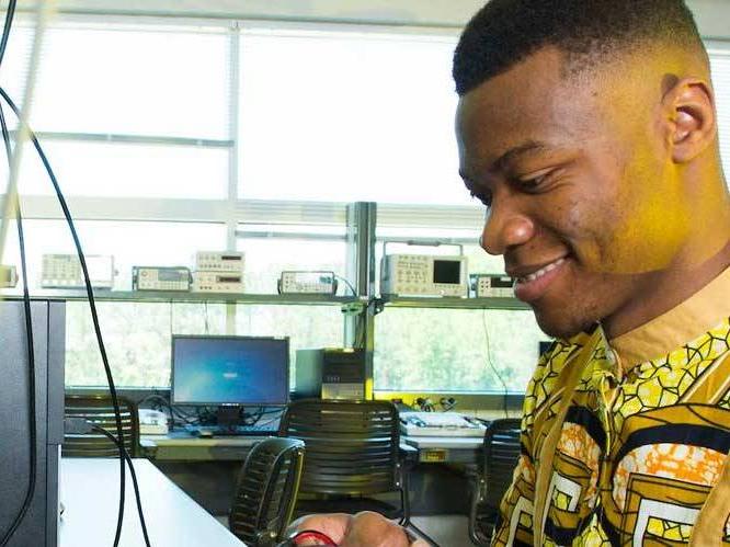 Man looking at a computer monitor with a wire hanging down infront of it